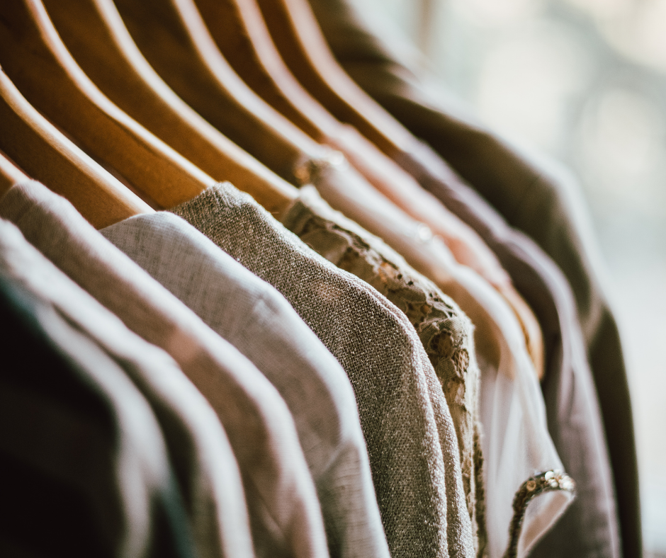What items go to the dry cleaners? A collection of shirts hanging on wooden hangers